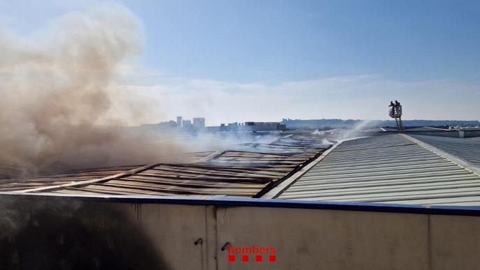 Els Bombers treballen en l'extinció d'un incendi en una nau industrial a Cervera