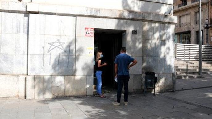 Imatge de dues persones esperant a l'entrada de l'edifici d'Economia de Sant Francesc de la Paeria de Lleida